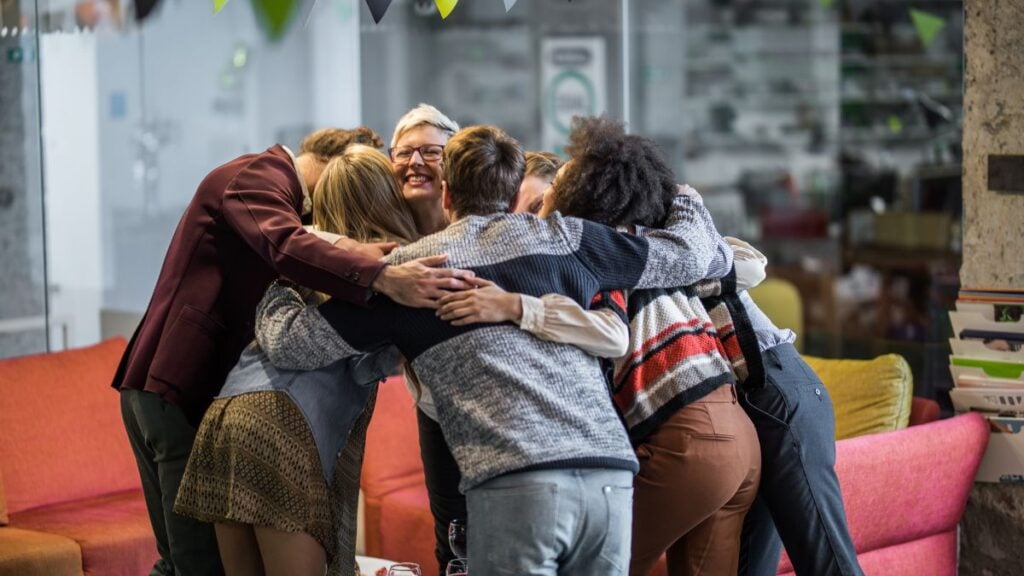 pessoas se abraçando em grupo