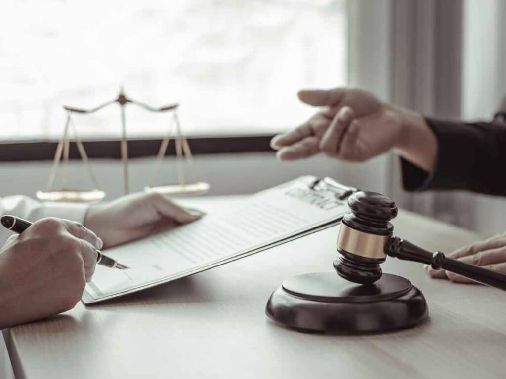 Advogado especializado em Direto do Trabalho, em seu escritório, explicando para seu cliente, dono de empresa, o motivo de suas instituição estar sendo penalizada pela falta de contribuição.