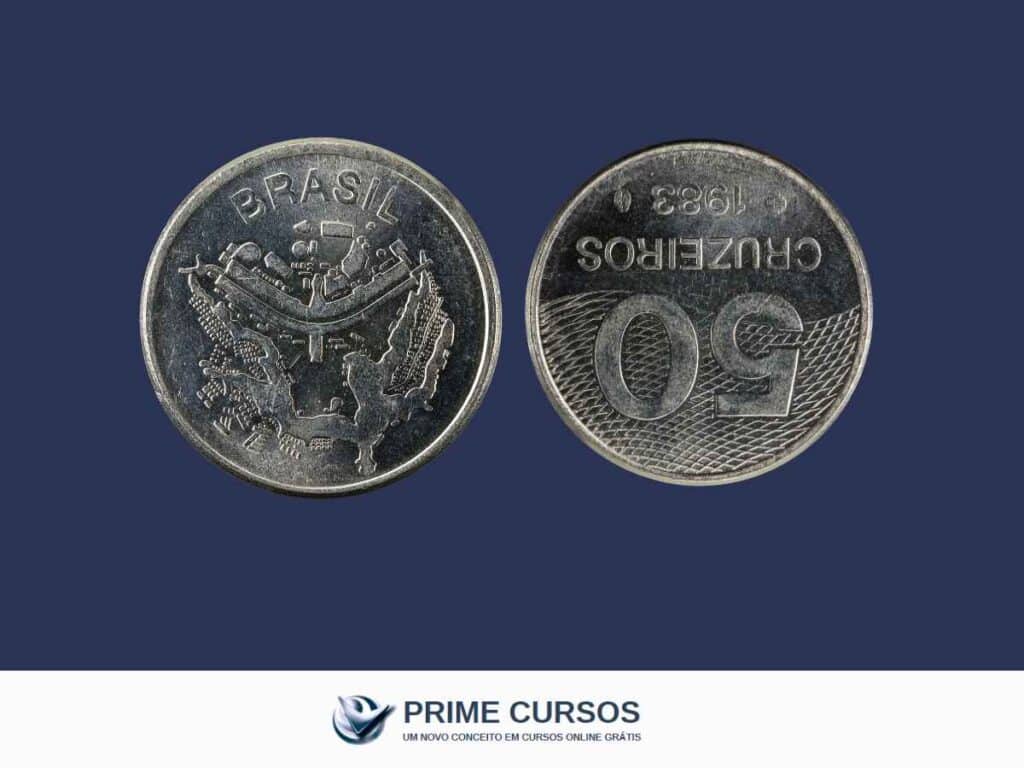 Moeda brasileira de 50 cruzeiros do ano de 1983, exibindo o reverso invertido. Ao fundo, o logotipo da Prime Cursos.
