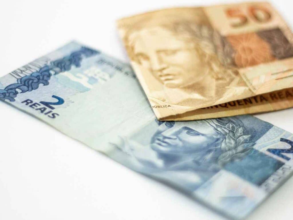 Notas de dois e cinquenta reais sobre superfície branca