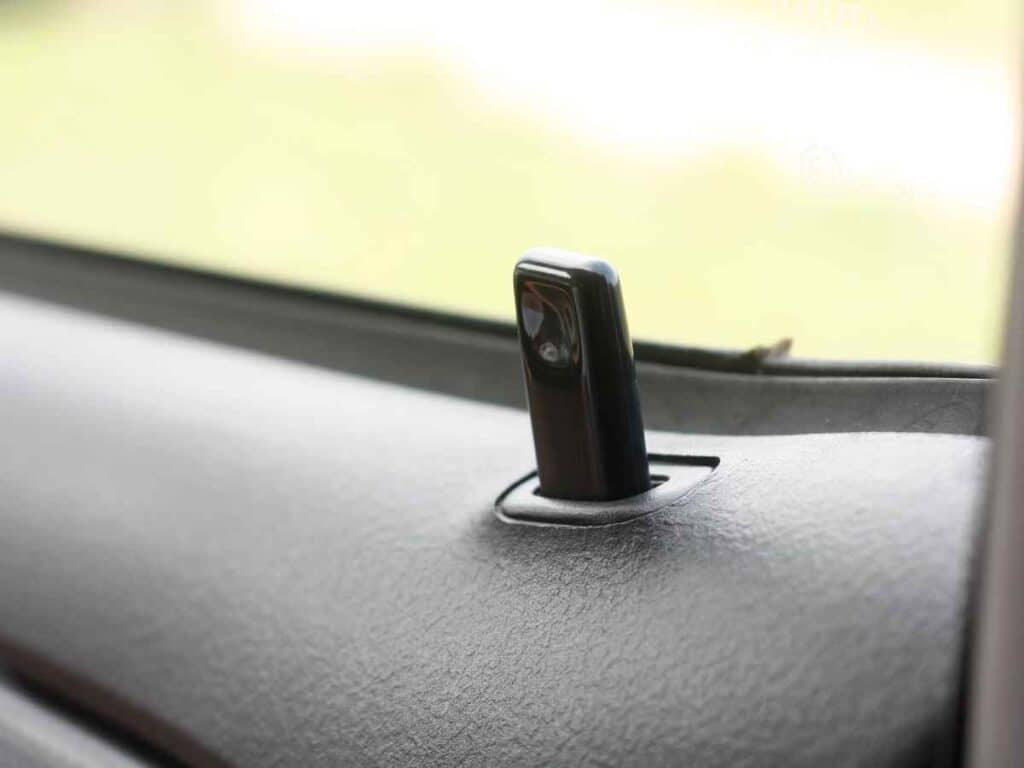 Detalhe de uma trava de porta de carro em foco, representando segurança automotiva e proteção contra invasões.